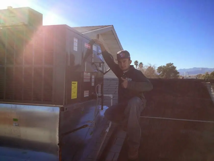 HVAC technician performing Air Duct Cleaning on a rooftop unit in Hamden